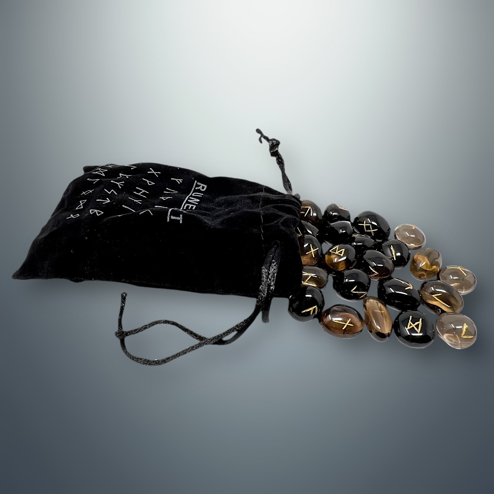 Bolsa pequeña de terciopelo negra con inscripciones rúnicas, de la cual salen algunas runas de cuarzo ahumado.