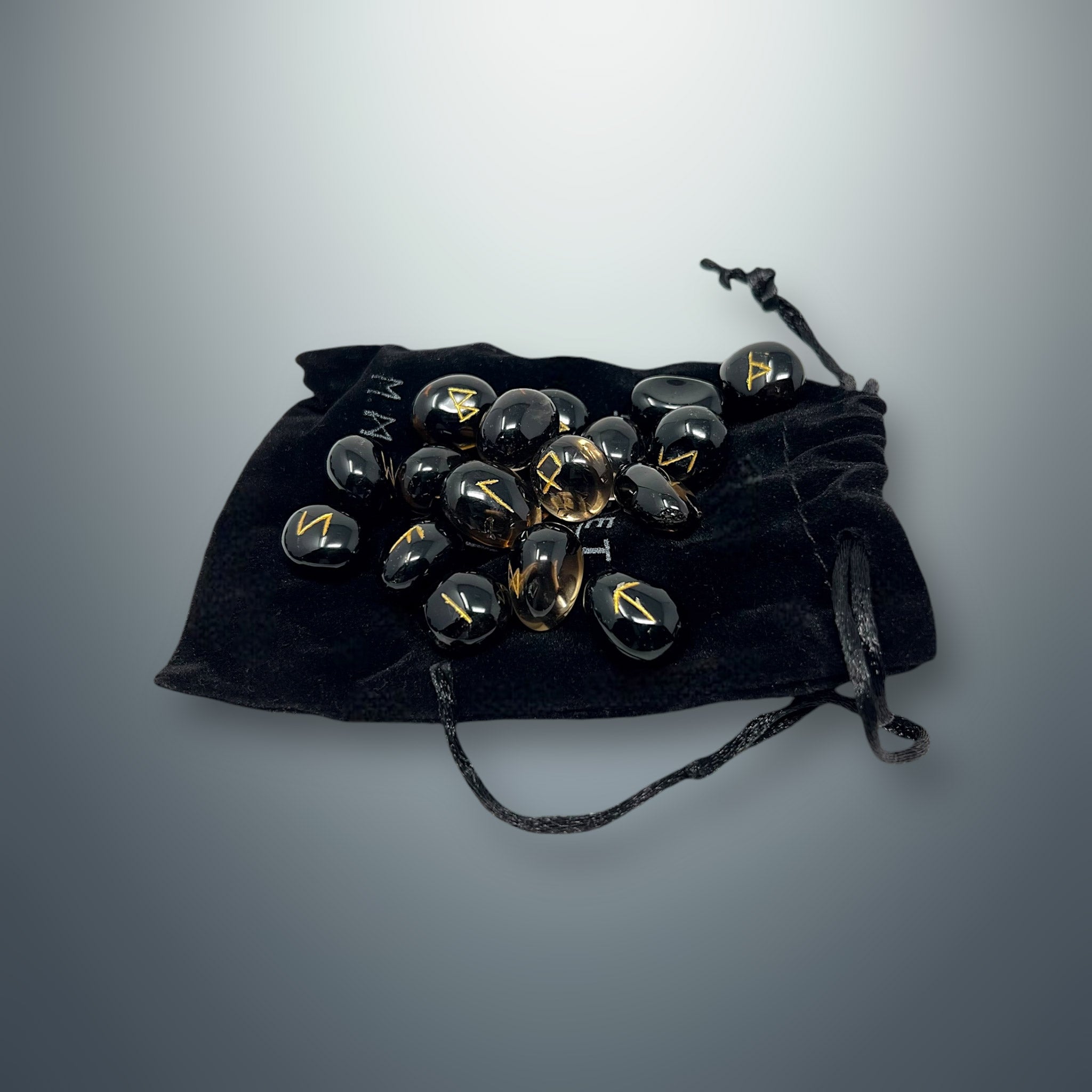 Set de runas de cuarzo ahumado sobre una bolsa pequeña de terciopelo negro.
