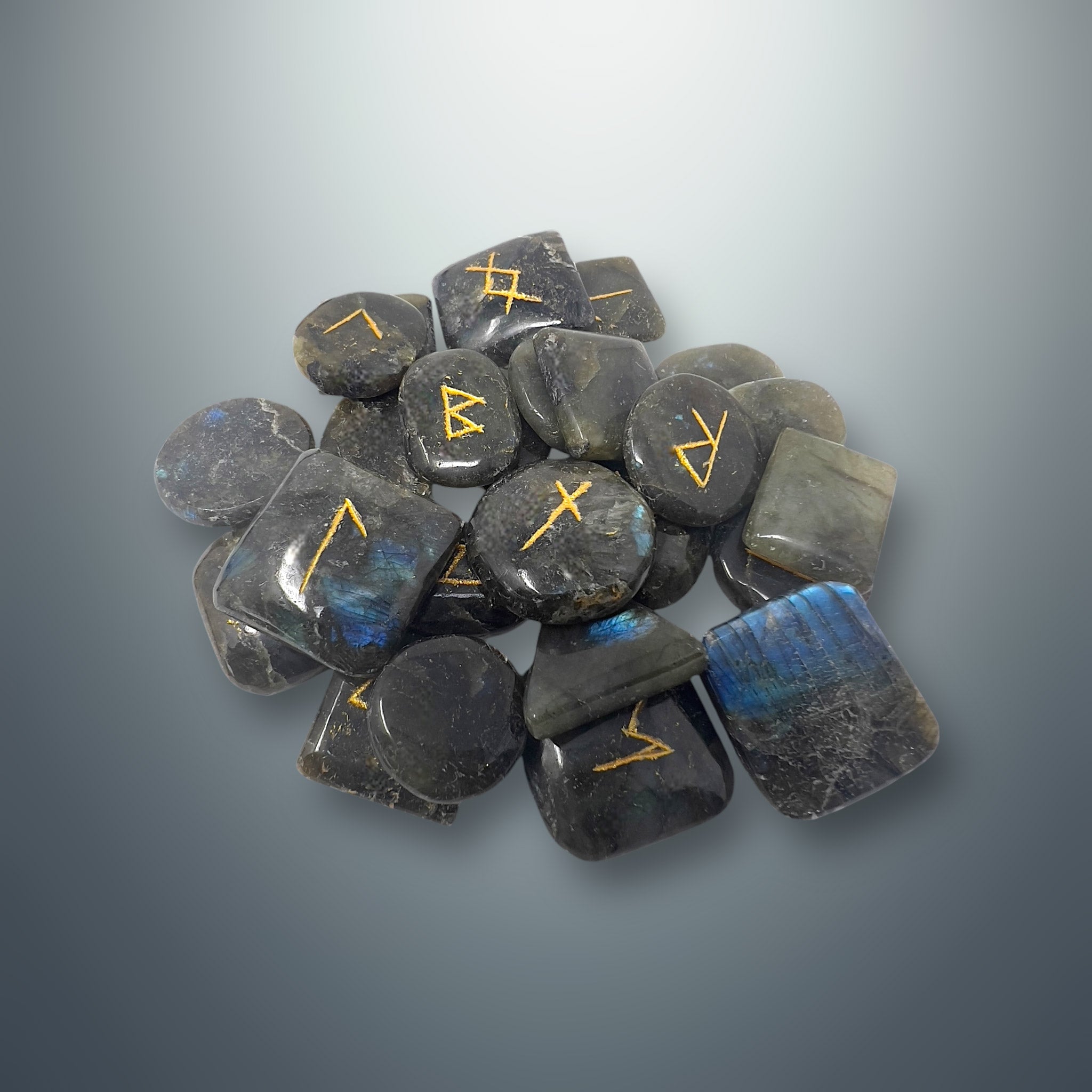 Set de runas de labradorita con los símbolos rúnicos grabados en color dorado.