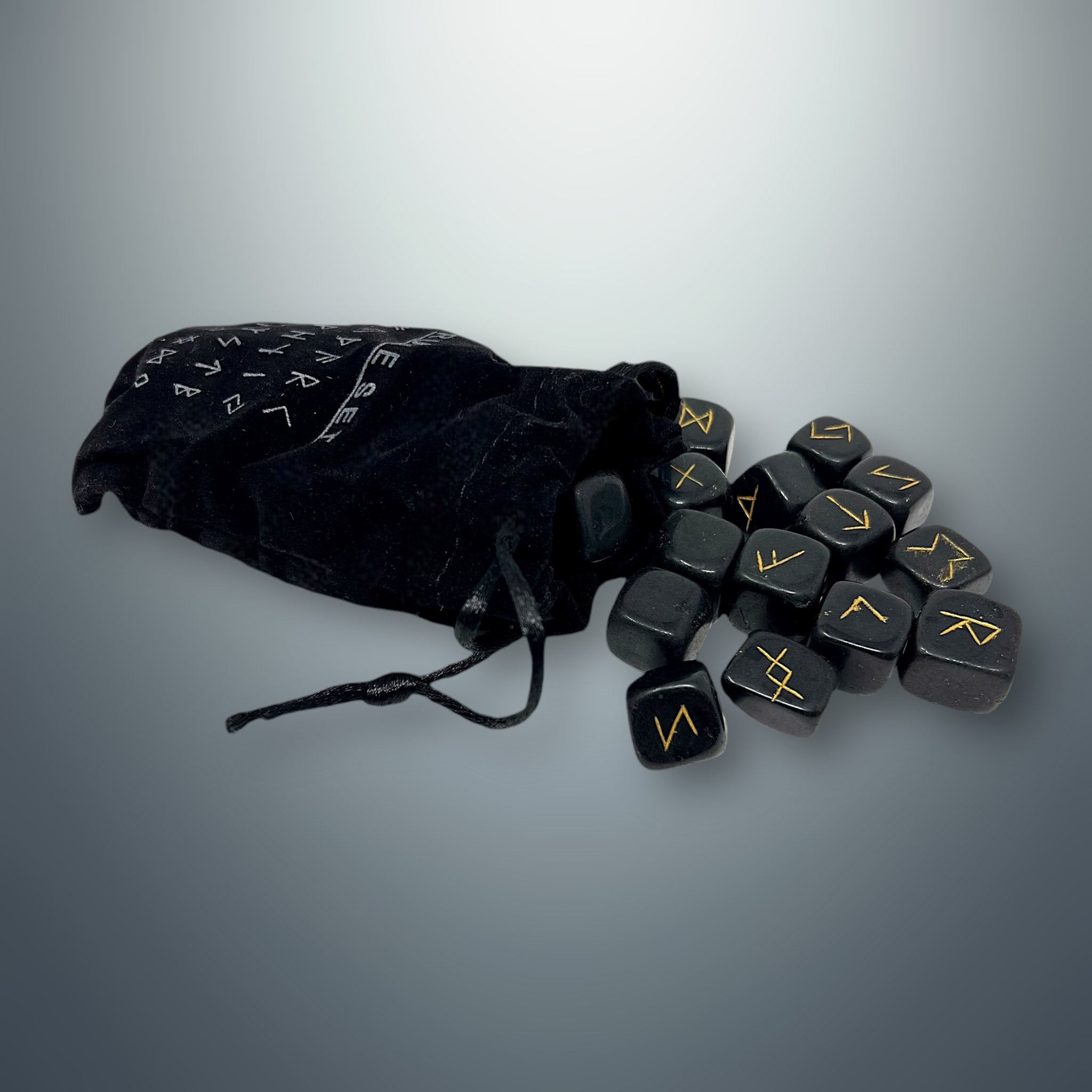 Bolsa pequeña de terciopelo negra con inscripciones rúnicas, de la cual salen algunas runas de turmalina negra.