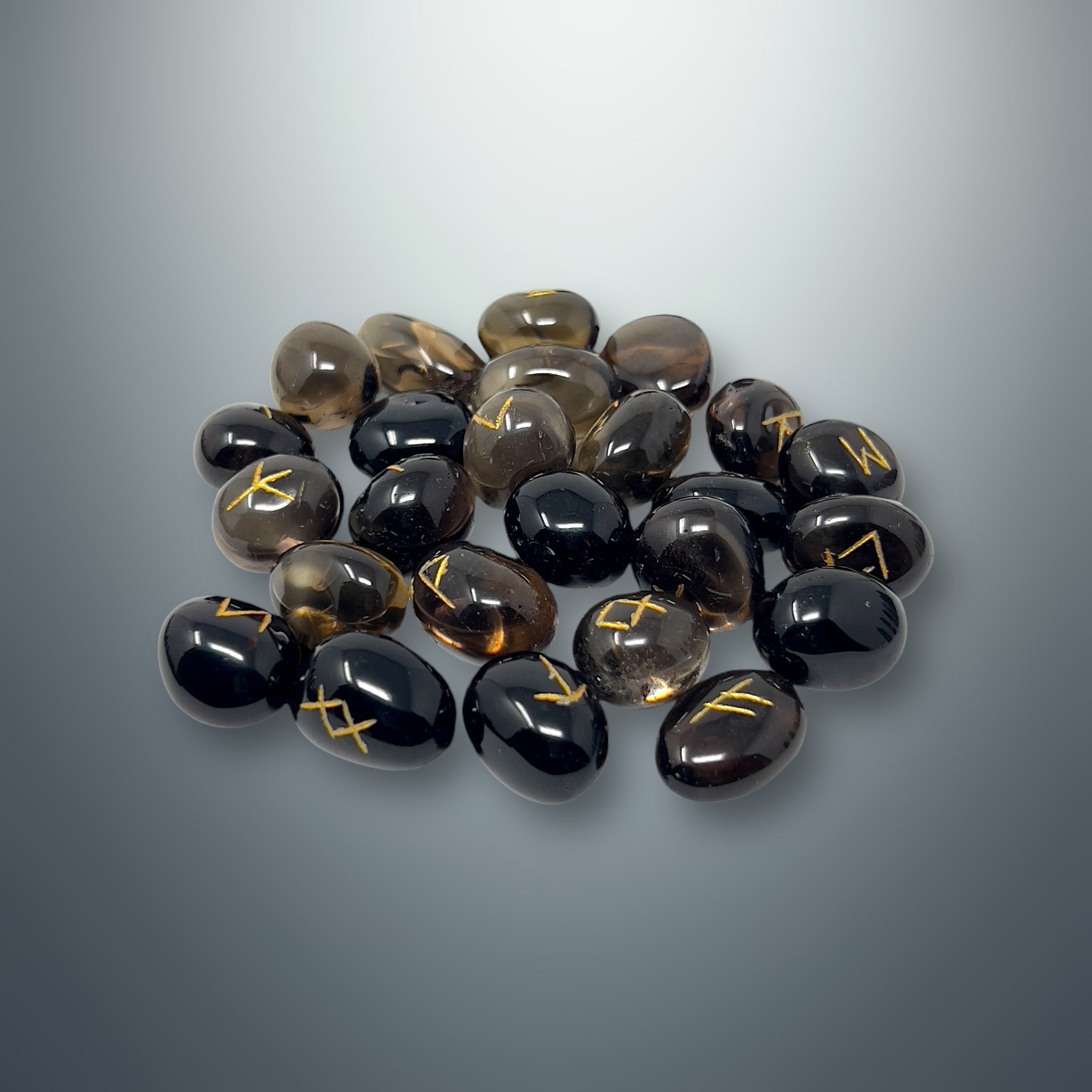 Set de runas de cuarzo ahumado con los símbolos rúnicos grabados en color dorado.