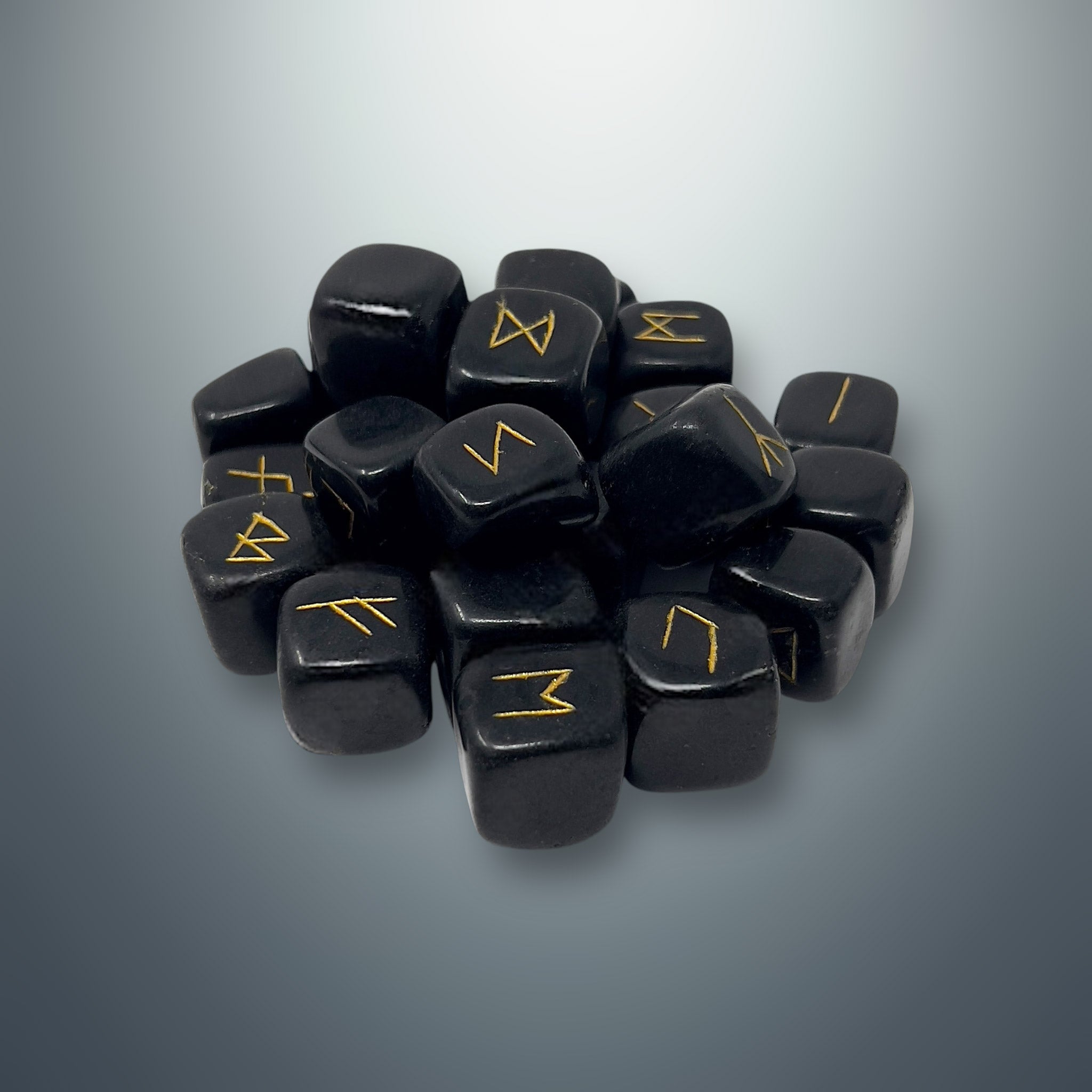 Set de runas de turmalina negra con los símbolos rúnicos grabados en color dorado.